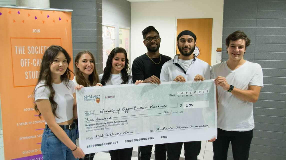 Photo of McMaster students holding a large novelty check