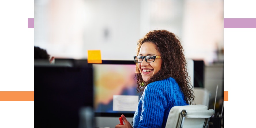 woman sitting in an office setting smiling