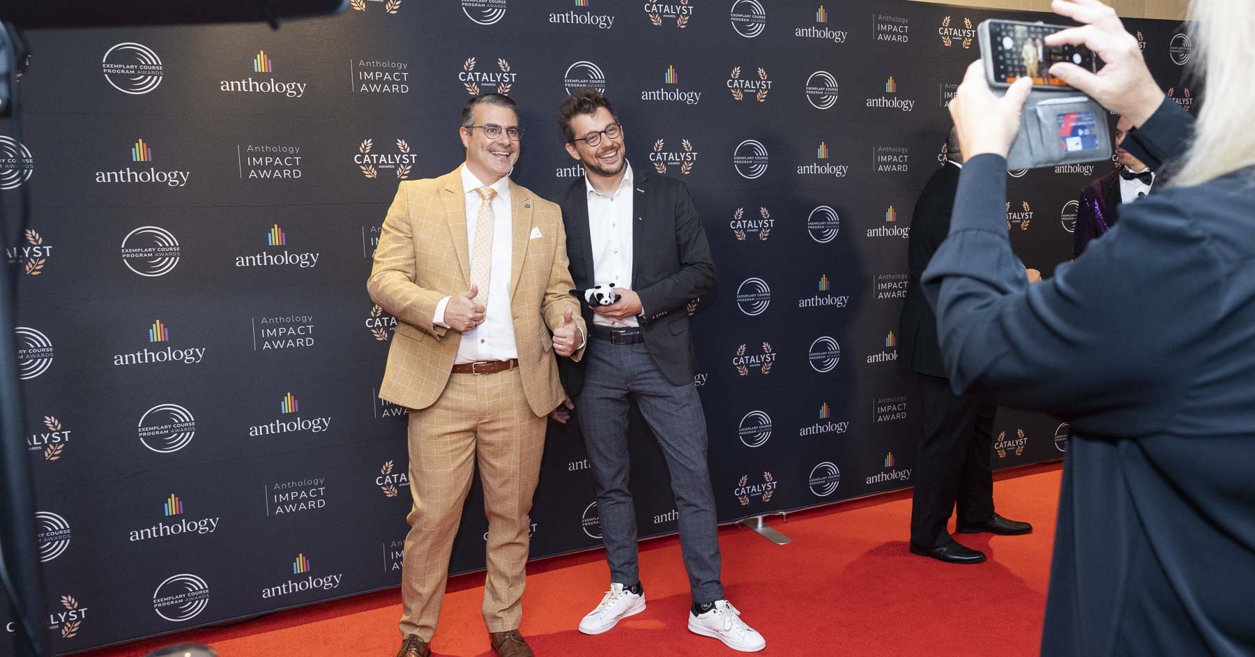 Two attendees smiling by the Catalyst backdrop