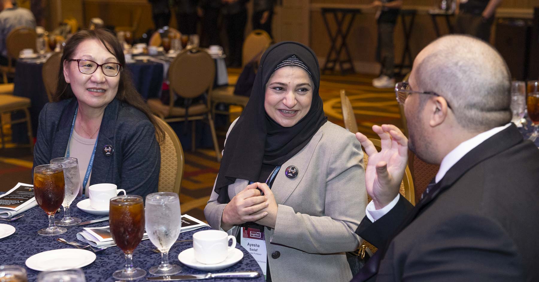 Three attendees networking at the dinner event