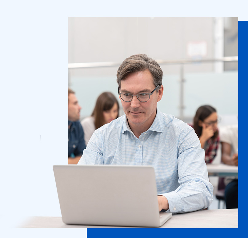 Photo of a man working at a laptop in a shared space