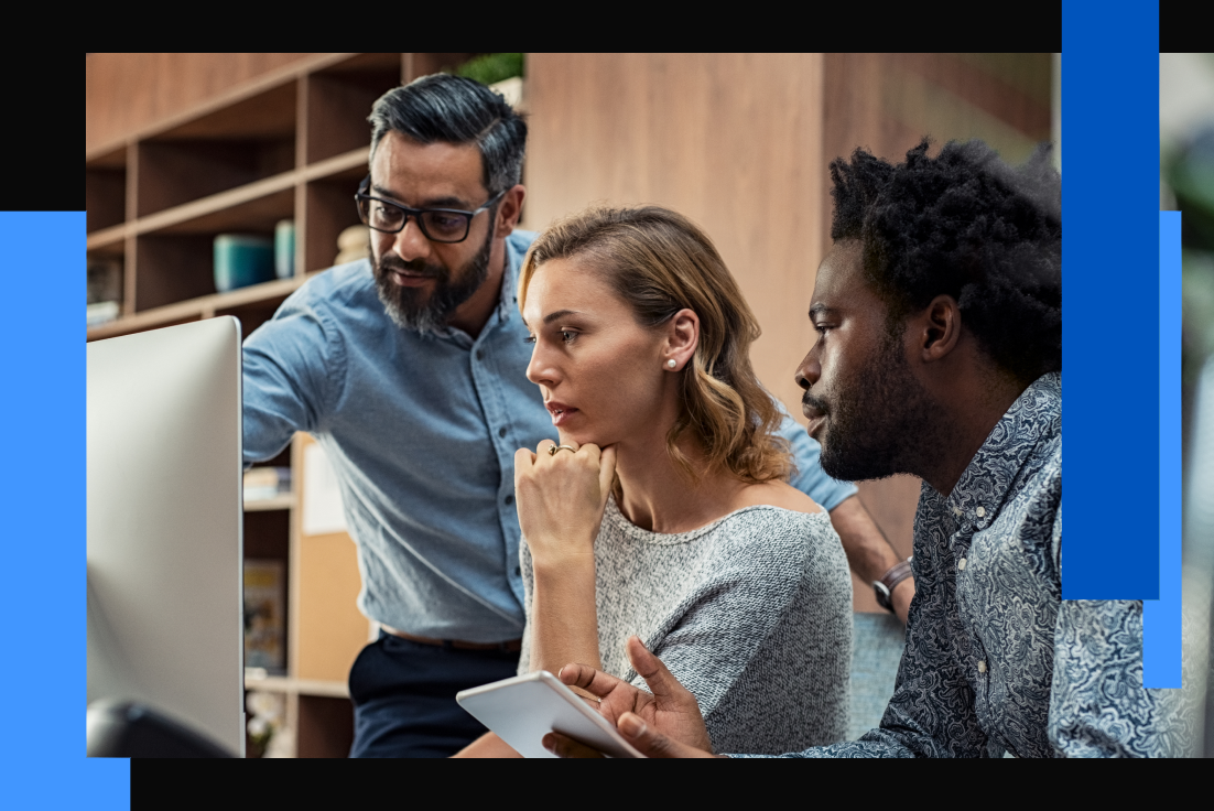 Photo of three people working around a computer