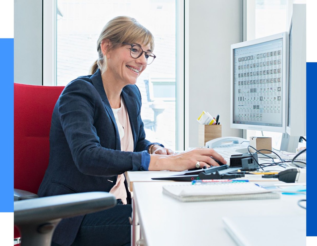 Photo of a woman working at a computer on her desk