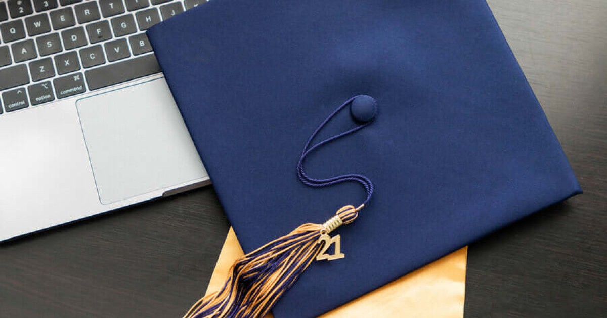 Photo of a graduation cap on top of a laptop