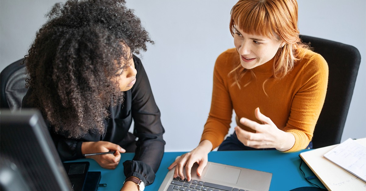 Photo of two women working at a laptop