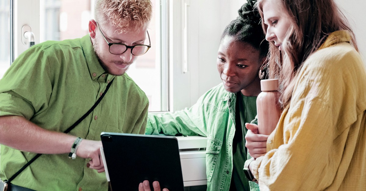 3 people meeting over a tablet