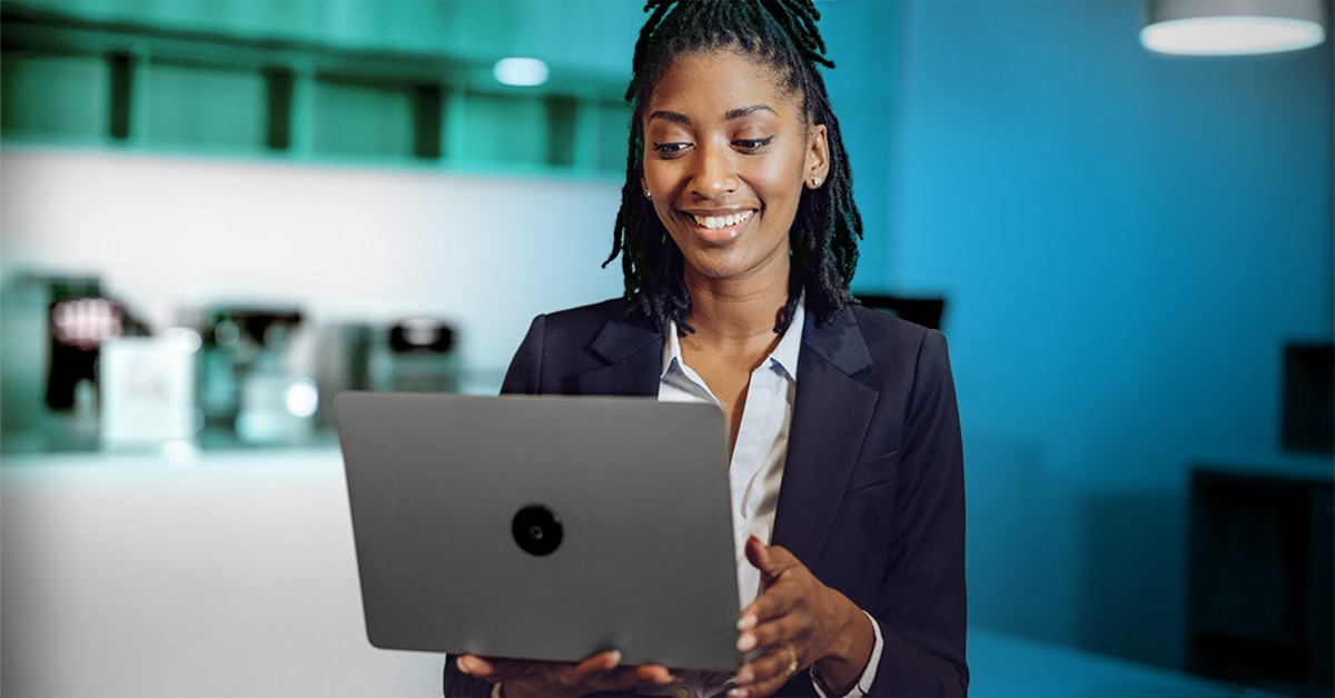 Photo of a woman walking with her laptop