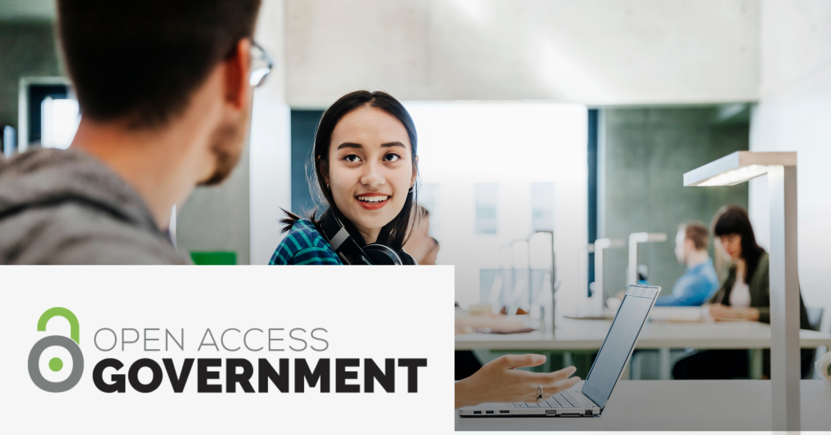 Image with the Open Access Government logo on the lower left corner and a picture of two students talking while working with a laptop. 