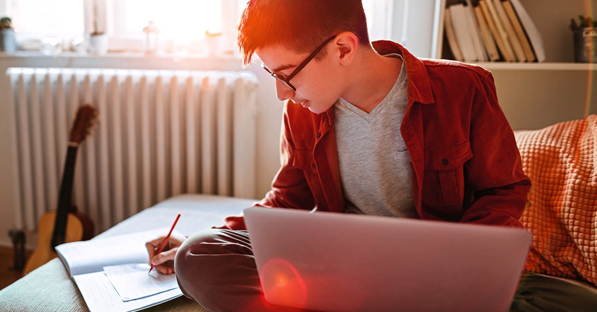 Person doing schoolwork in a bedroom setting