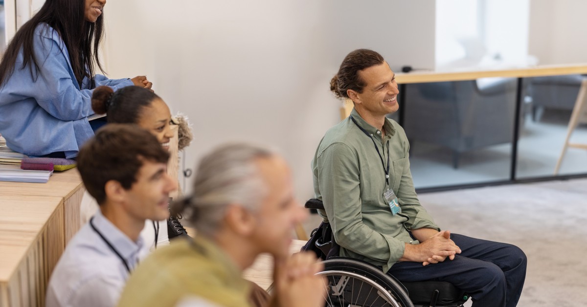 Photo of people, including one in a wheelchair, attending a lecture
