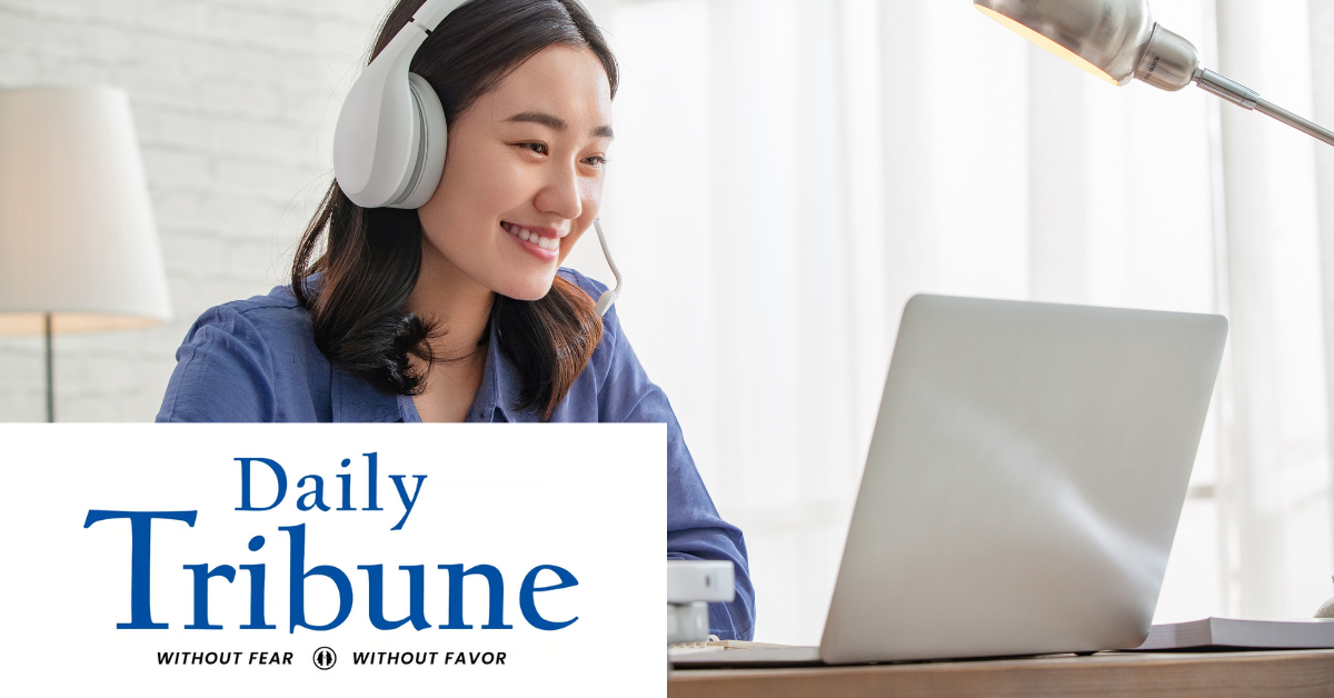 Daily Tribune logo on the left corner. Image of woman smiling at her laptop.