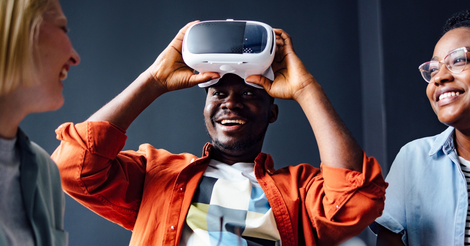 Coworkers smiling and using a virtual reality headset