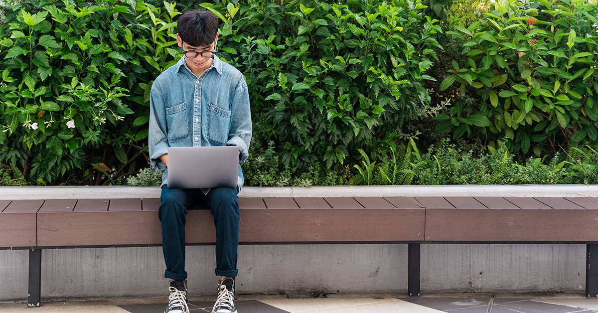 A student working on their laptop outside