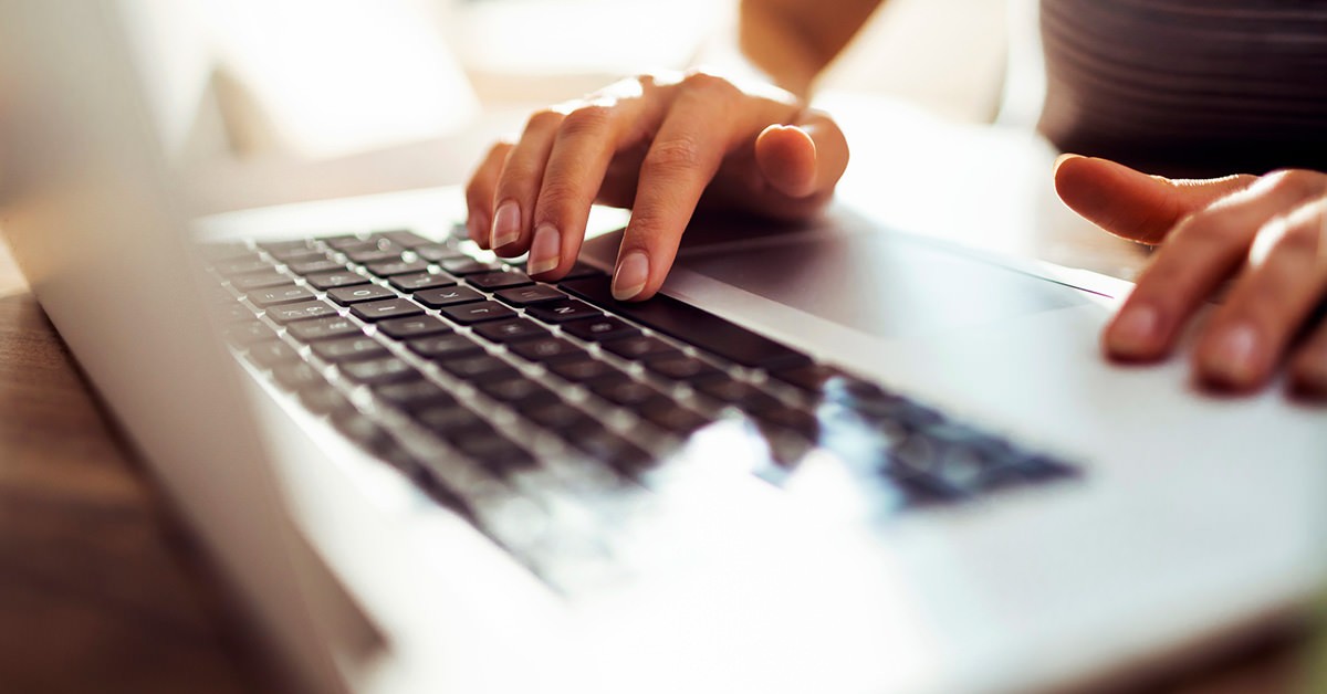 Photo of hands working at a laptop