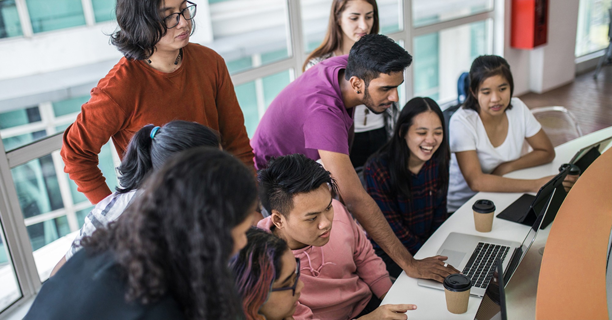 Photo of a group of students around a laptop