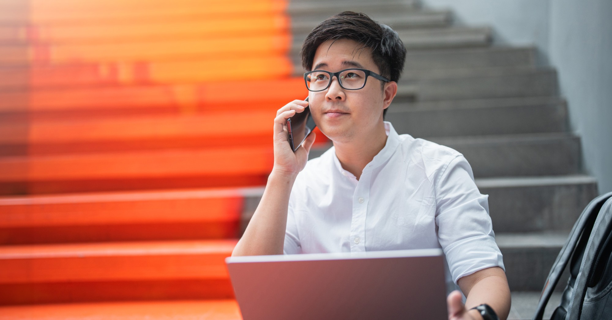 Photo of a person on the phone with IT support while working on their laptop