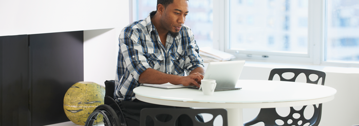 Wheelchair-bound person using laptop for class access